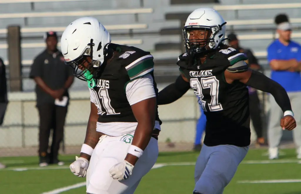 Evans defensive tackle Chance Bell (91) in congratulated by teammate Zayvion Laster (27) after his second sack on the day Saturday during a jamboree at Lakeland. (Chris hays/Orlando Sentinel)