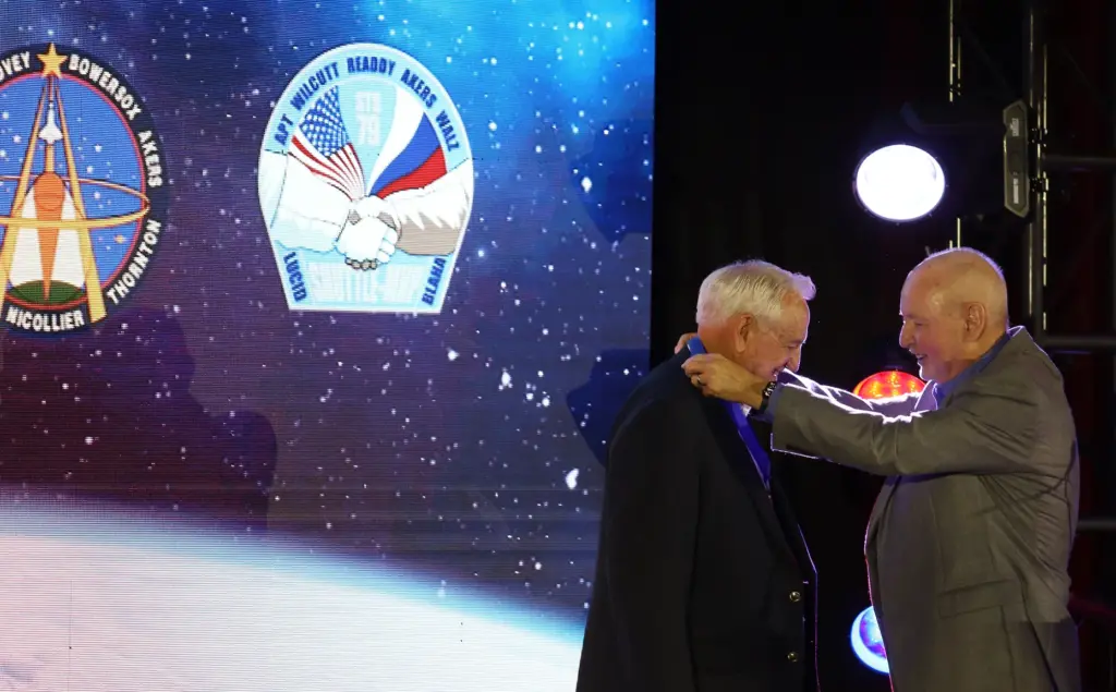 Former NASA astronaut Tom Akers, left, receives a medal from...