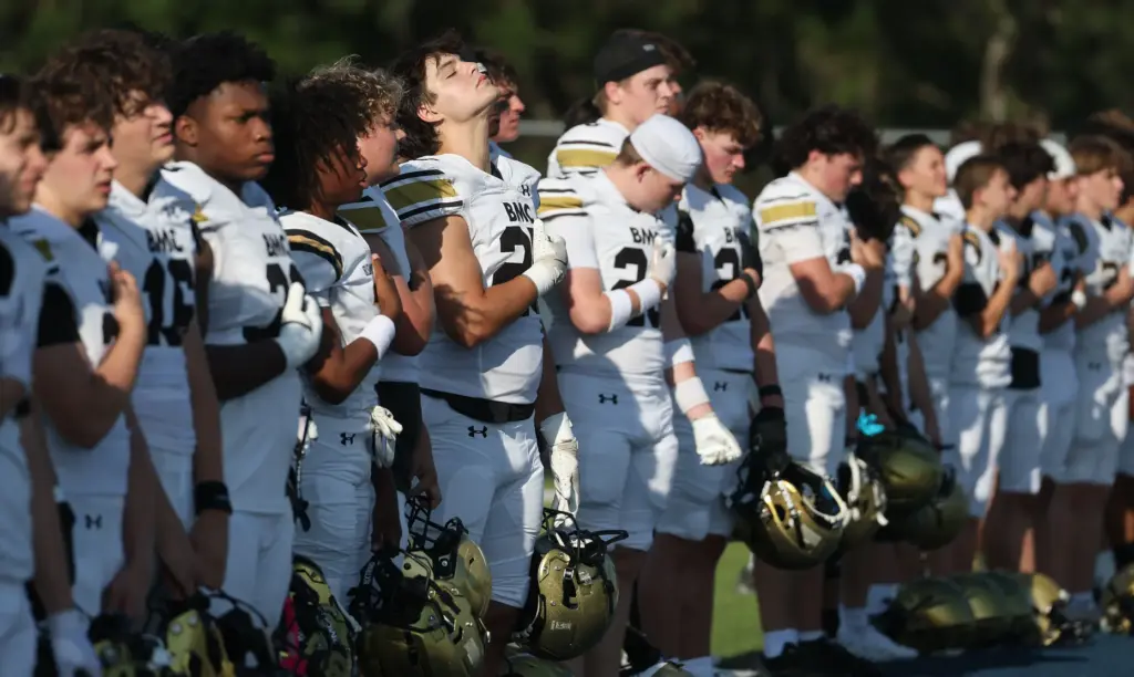 Bishop Moore players are pictured during the national anthem before...