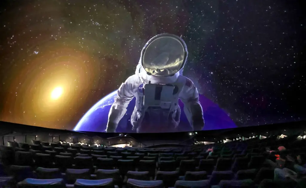 A scene is projected on the massive screen of the...