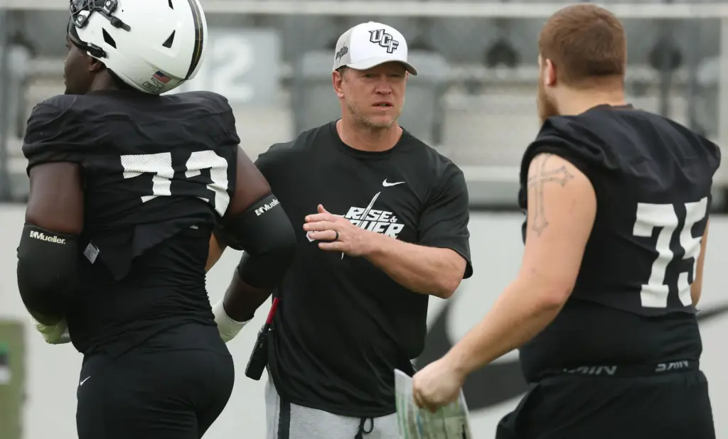 UCF head coach Scott Frost greets offensive linemen Henry Tabansi...
