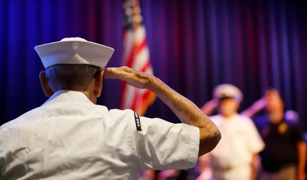 US Navy veteran William Matheos salutes during the Memorial Day...