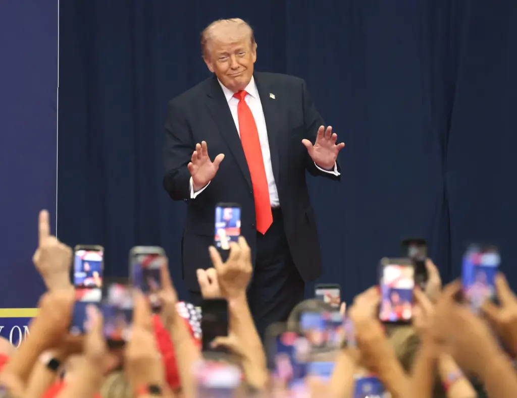 President Donald Trump responds to a cheering crowd as he...