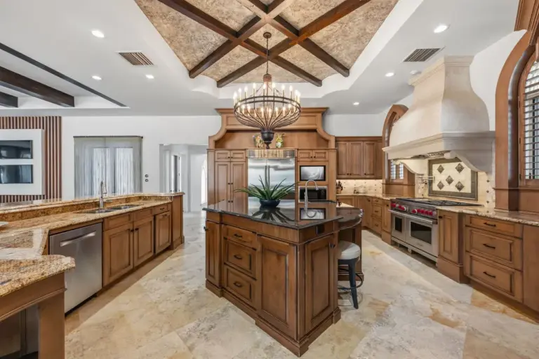 The gourmet chefâs kitchen features custom wood cabinetry, expansive stone...