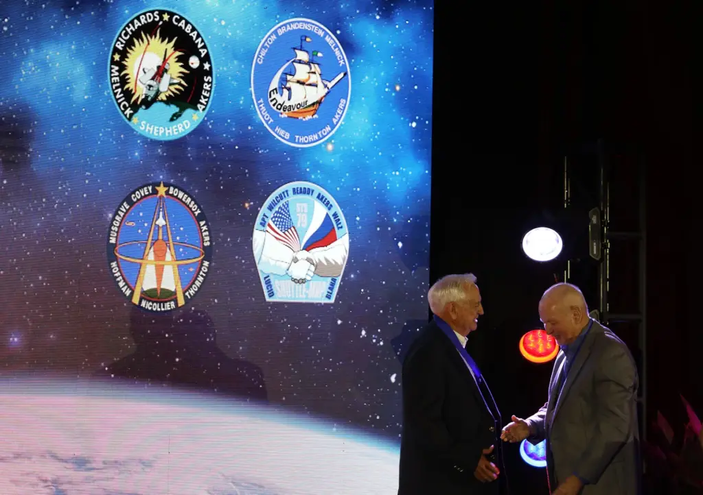 Former NASA astronaut Tom Akers, left, receives a medal from...