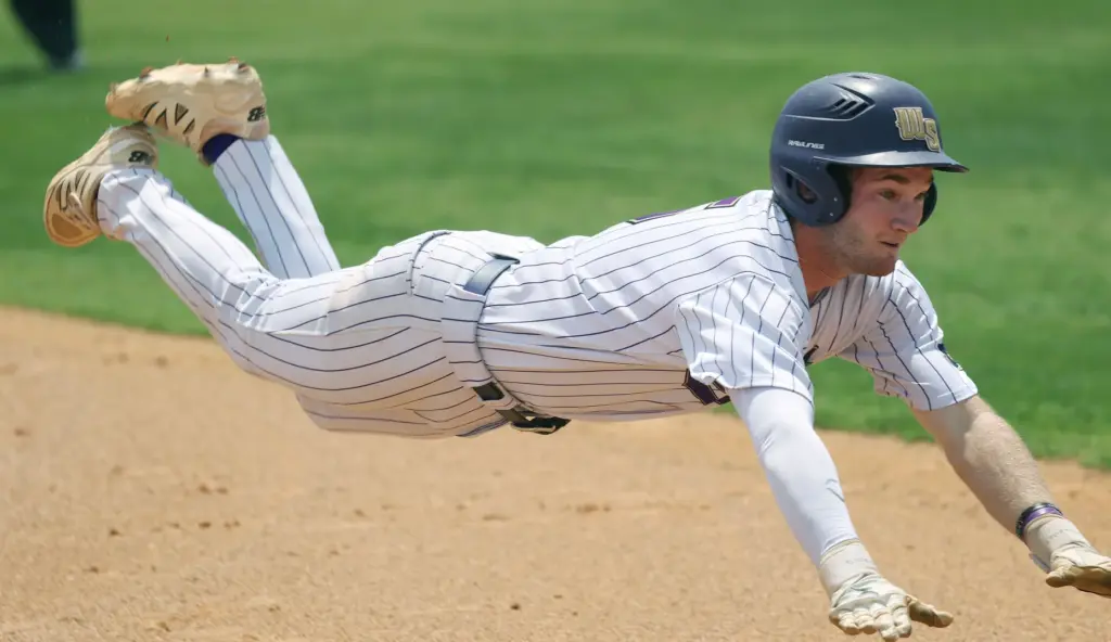Winter Springs High baseball player Brandon Curl slides into third...