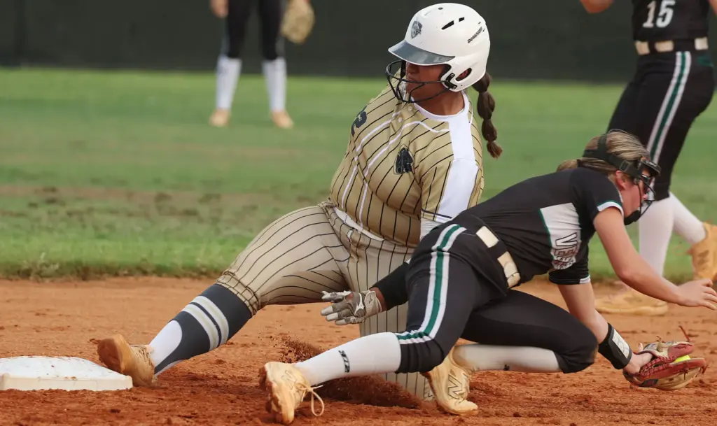 East Ridge High softball player Brianna Santos (left) slides safely...