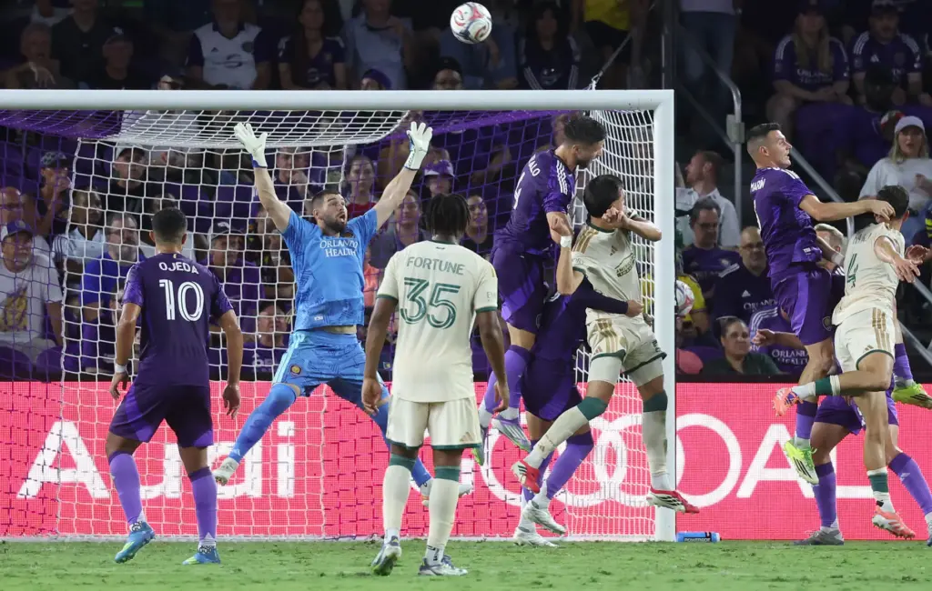 Orlando goalkeeper Maxime Crepeau (arms in air) leaps among players...