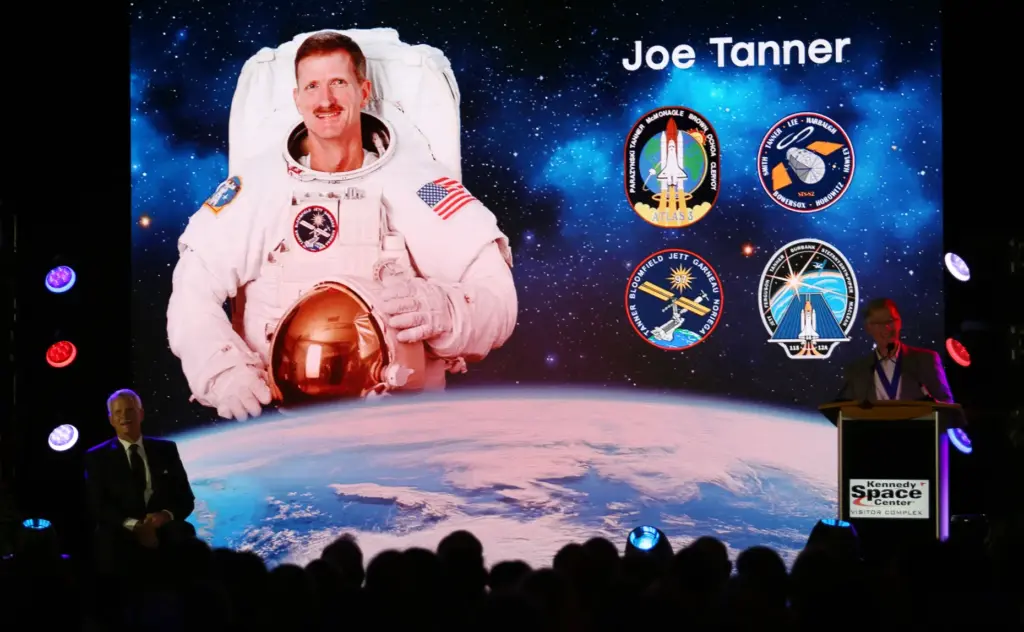 Former NASA astronaut Joe Tanner, left, listens to an introduction...