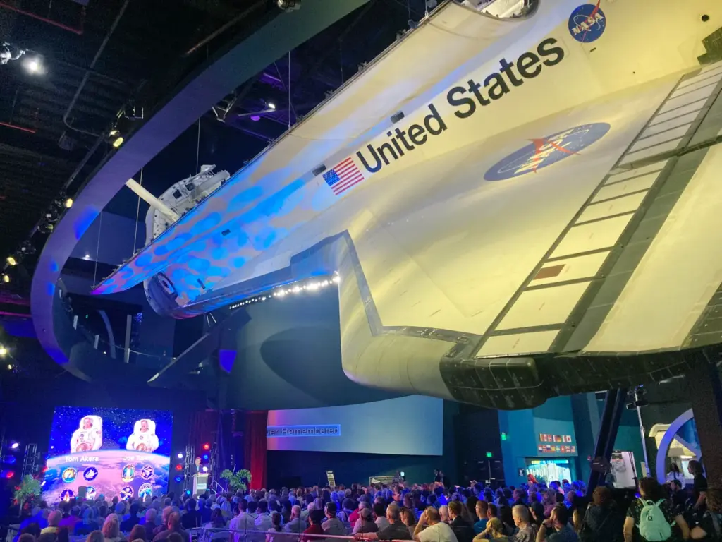 Crowds gather under Space Shuttle Atlantis on display during the...