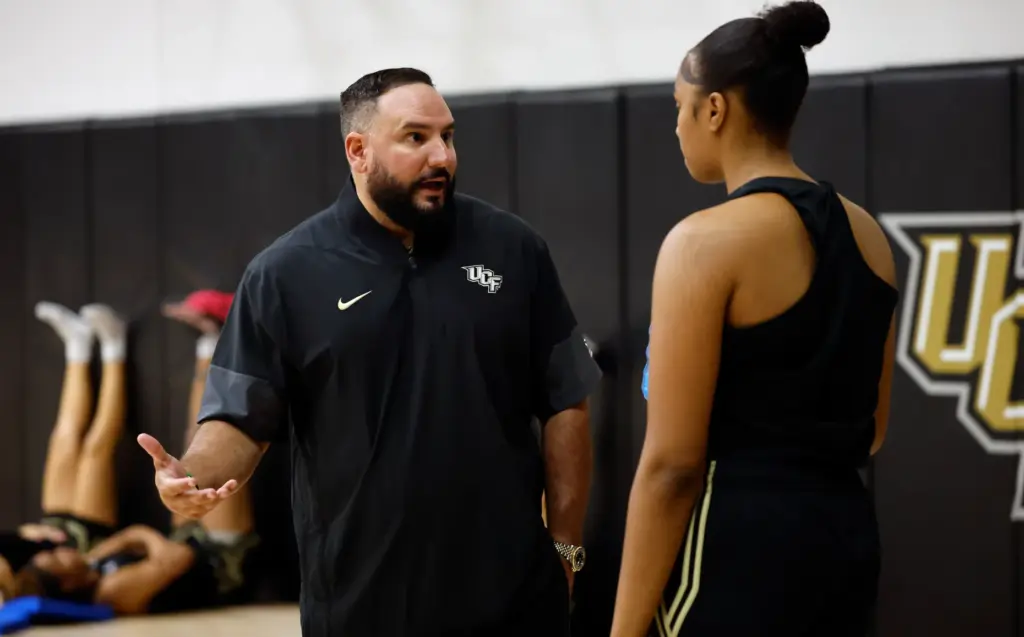 UCF women's basketball coach Gabe Lazo talks with forward Mahogany...