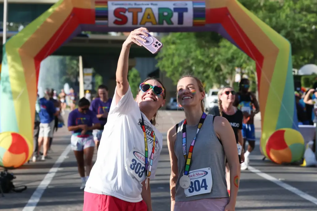 Runners celebrate their finish with a selfie during the 10th...