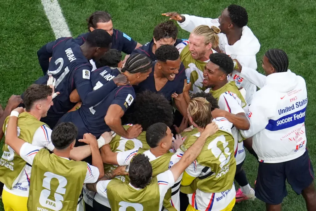 United States’ Auston Trusty, center, celebrates with teammates after scoring...