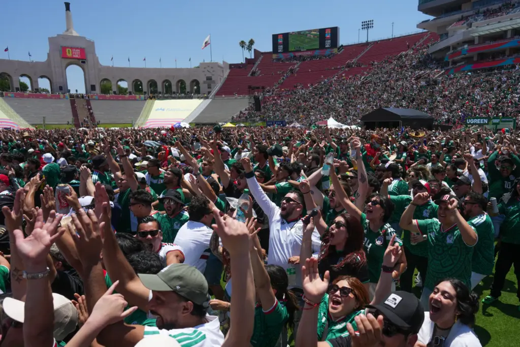 Fans celebrate a goal by Mexico while watching a live...