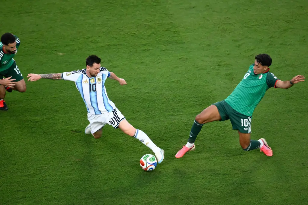 Argentina’s Lionel Messi (10) battles for the ball with Algeria’s...