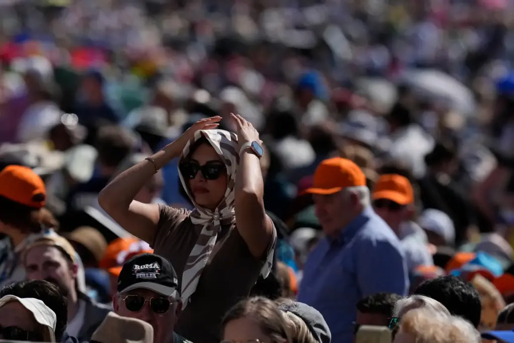 A faithful protects from the hot sun before Pope Leo's general audience.