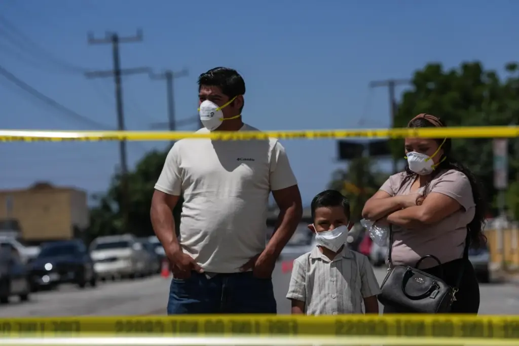 People wear masks while watching firefighters fight a warehouse fire...