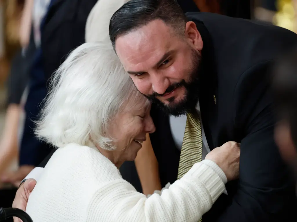 Mom Adela Aguiar gets a hug from Gabe Lazo, before...