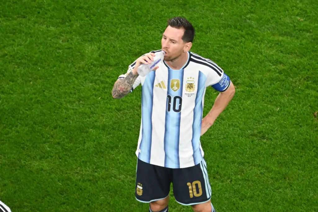 Lionel Messi drinks water during a hydration break.