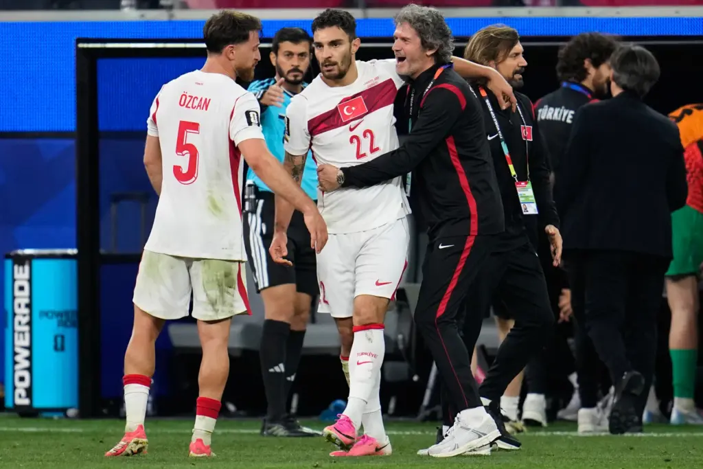 Turkey’s Kaan Ayhan (22) is congratulated by teammates after scoring...