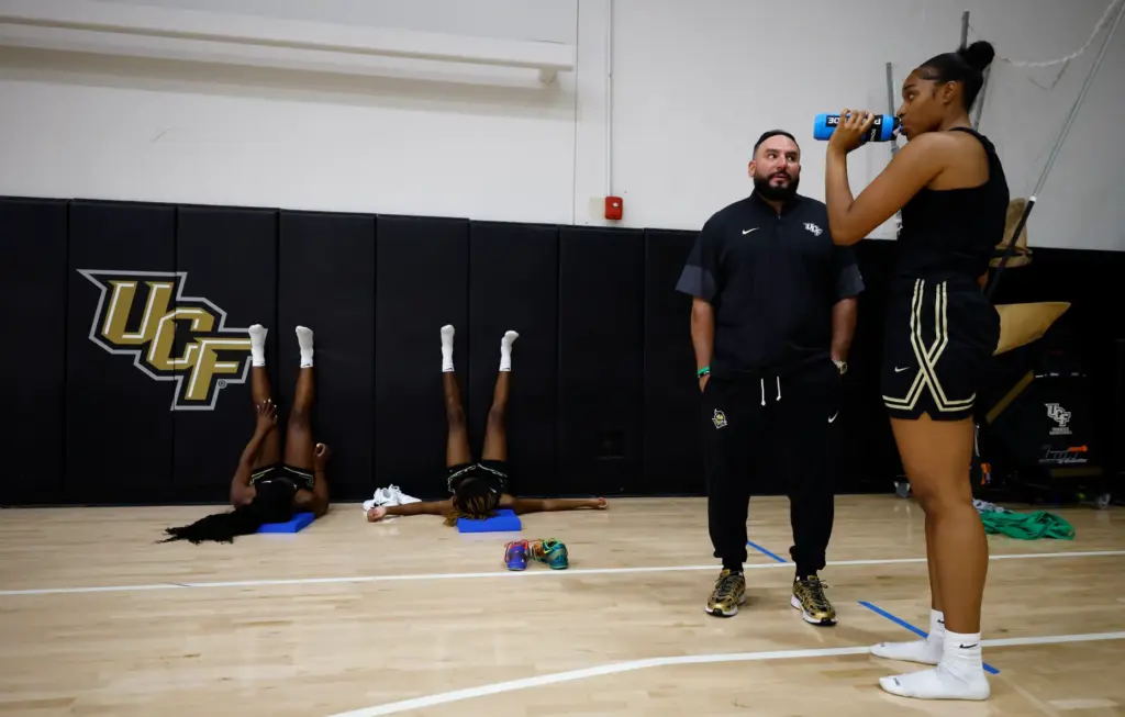 UCF women's basketball coach Gabe Lazo talks with forward Mahogany...