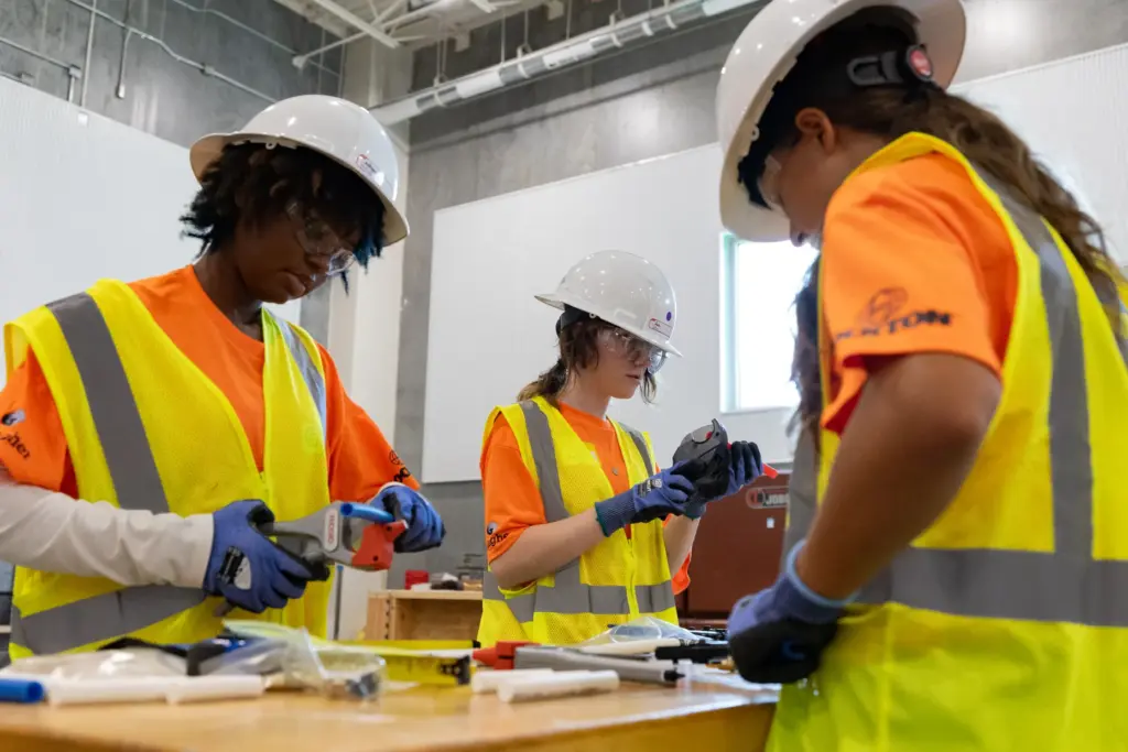 Focused campers work on a plumbing exercise using pipes that...