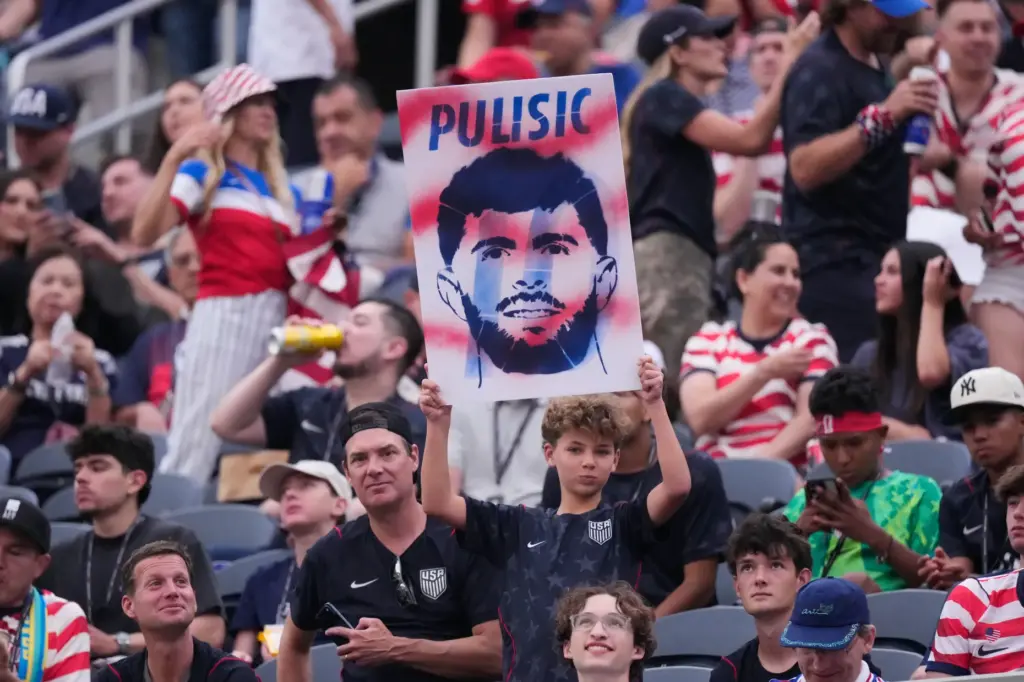 A fan displays a banner of United States’ Christian Pulisic...
