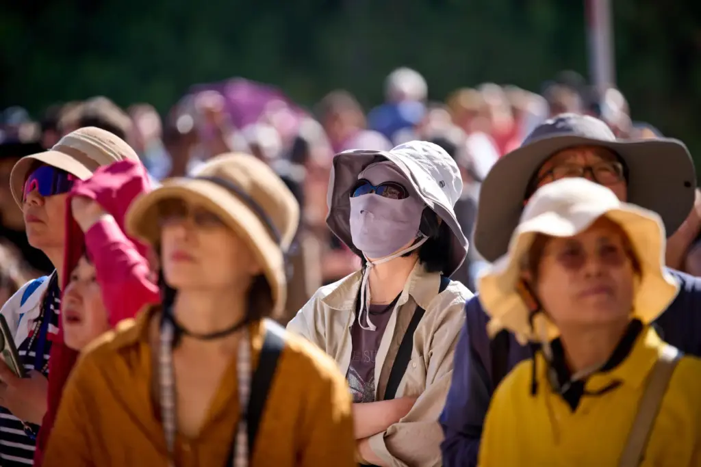 Tourists wear hats to protect themselves from the sun in Barcelona.