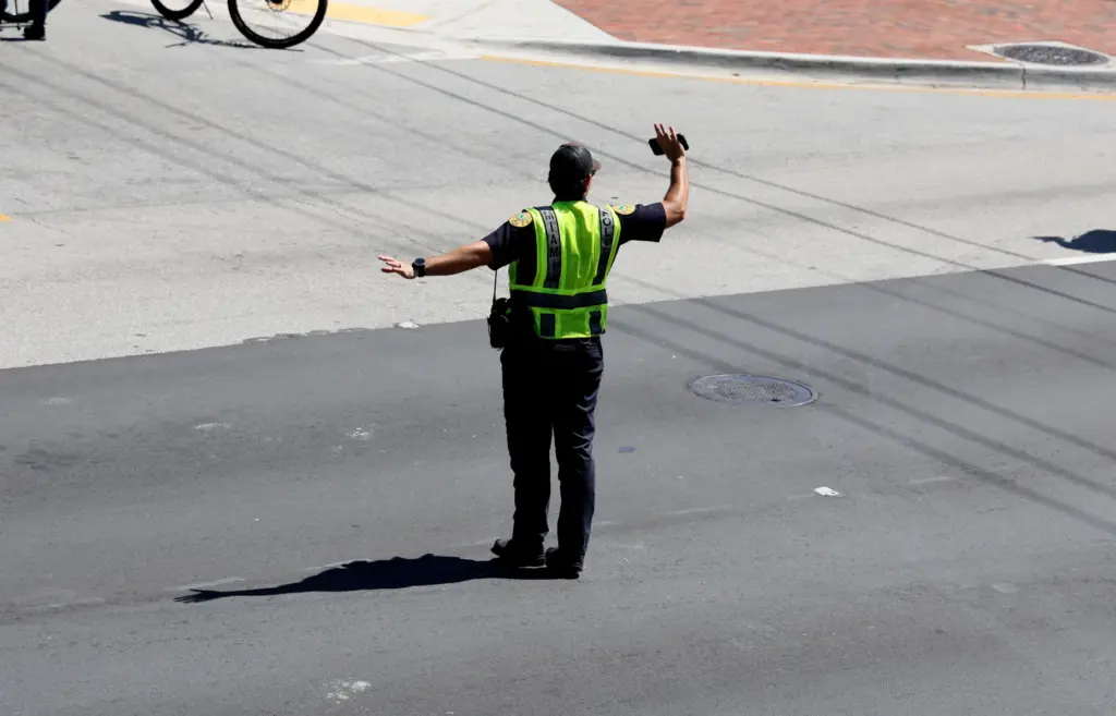 An officer directs traffic as World Cup fans participate in...