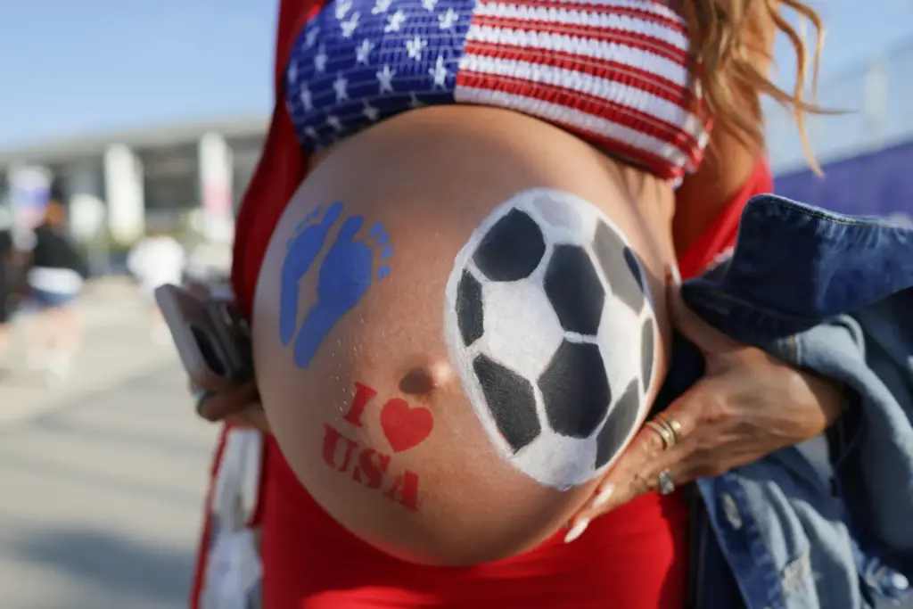 A pregnant woman with a painted belly arrives to watch...