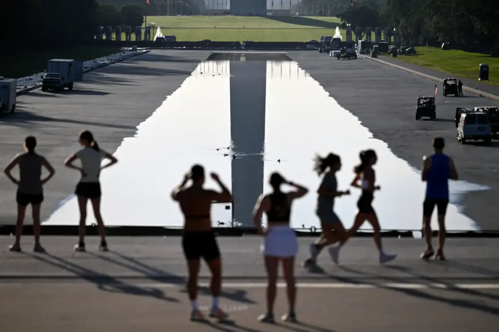 Early morning joggers observer the refilling of the Lincoln Memorial...