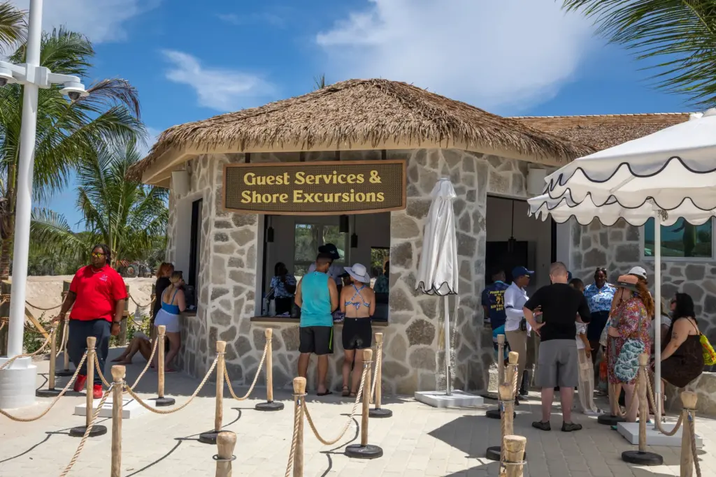 Guests visit the shore excursions and guest services desk at...