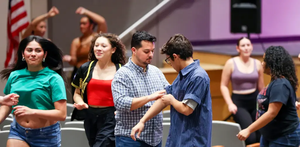 University High School Theater Director Alex Mendez, center, adjusts a...