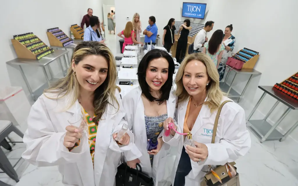 Attendees wear lab coats used in perfume creation during a...