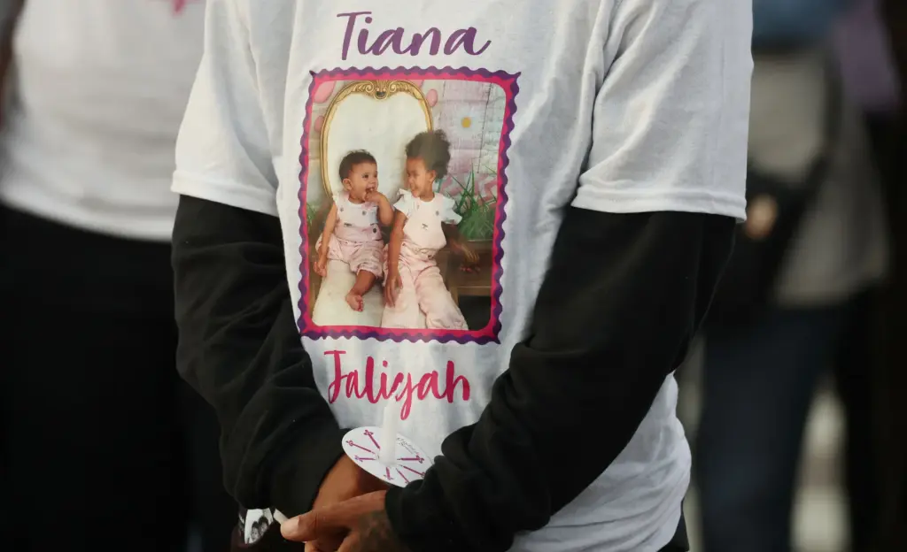 A mourner wears a memorial shirt during a community vigil...