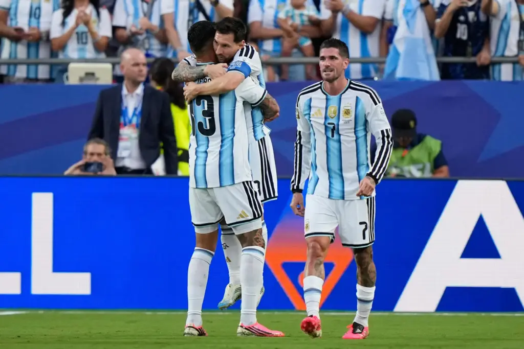 Argentina’s Lionel Messi is congratulated by teammate Cristian Romero, left,...