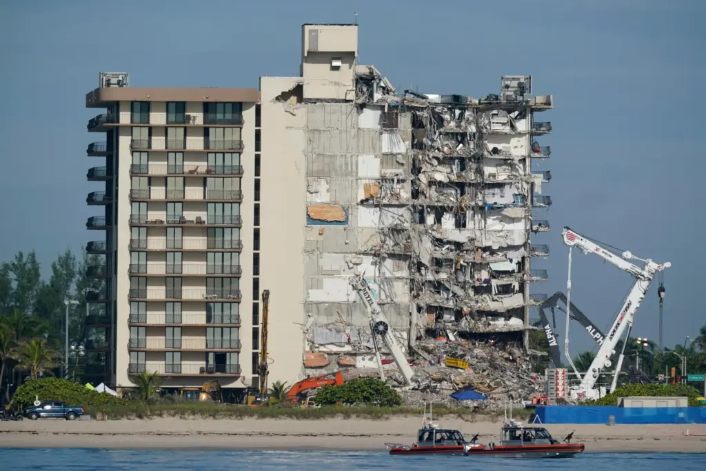 Coast Guard boats patrol in front of the partially collapsed Champlain Towers South condo building.