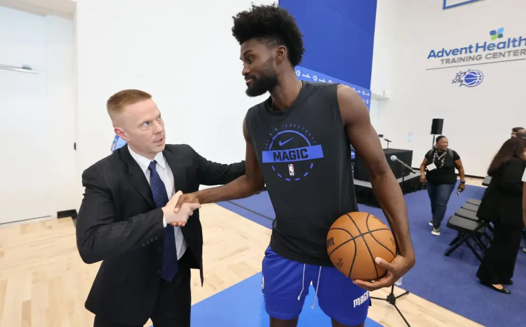New Orlando Magic head coach Sean Sweeney, left, greets Magic...