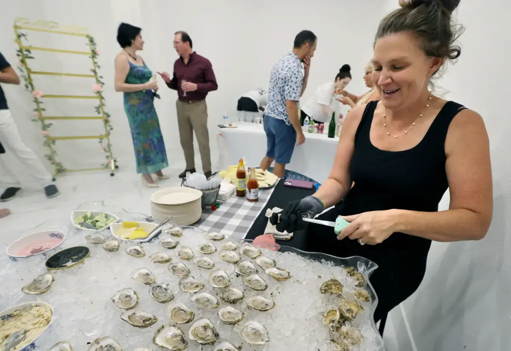 Lauren Dean, with Dean;s Oyster Bar, shucks raw oysters during...