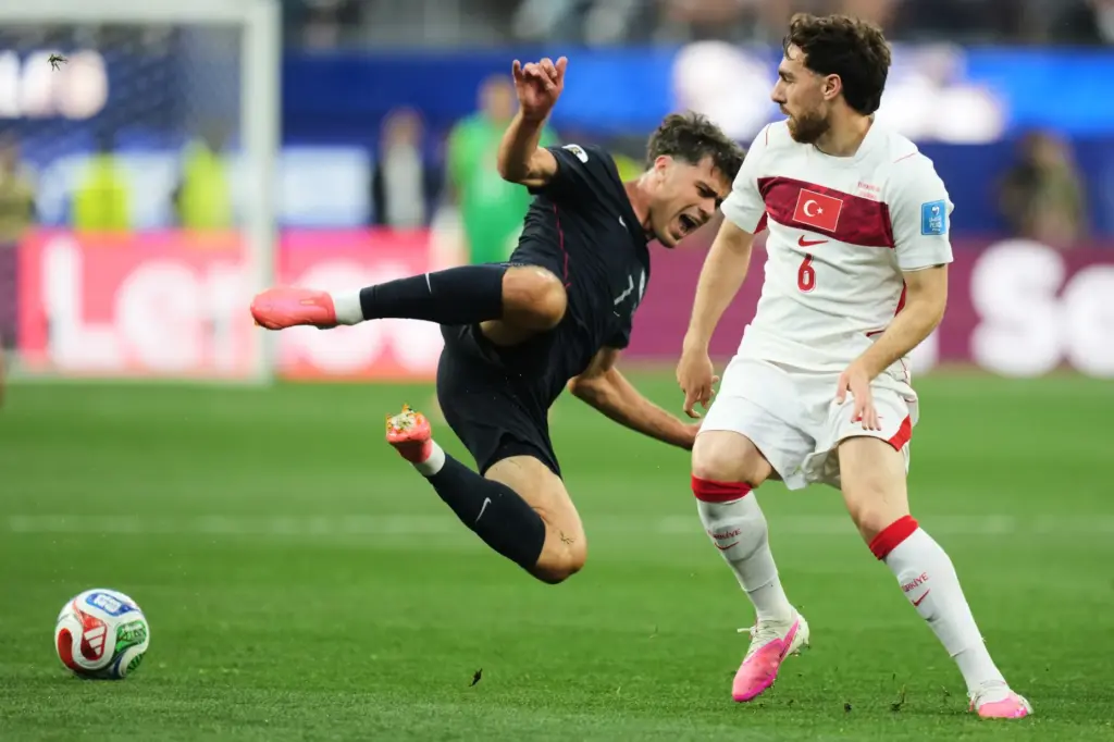 United States’ Giovanni Reyna falls as Turkey’s Orkun Kokcu looks...