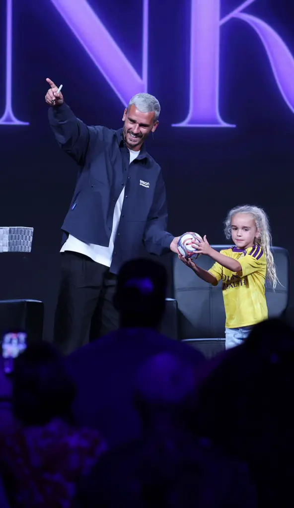 Antoine Griezmann hands a young girl kick an autographed soccer...