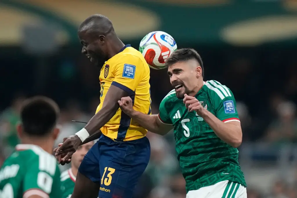Ecuador’s Enner Valencia (13) battles for a header with Mexico’s...