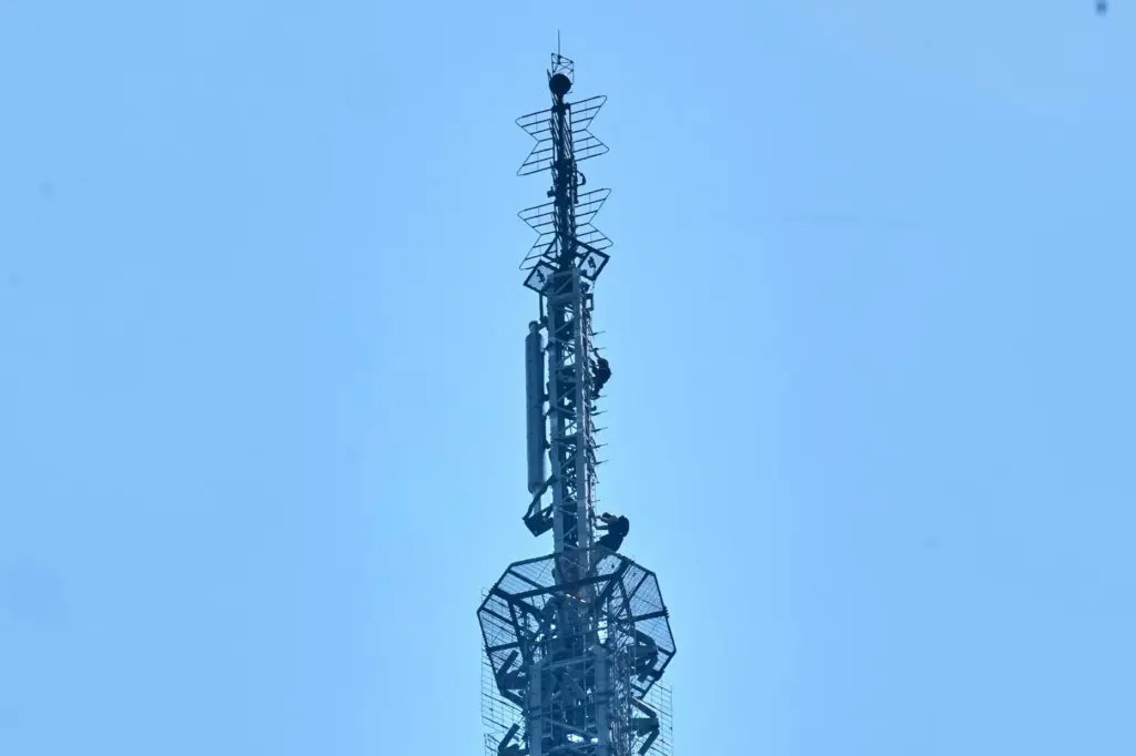 Two people descend the spire of the Empire State Building,...