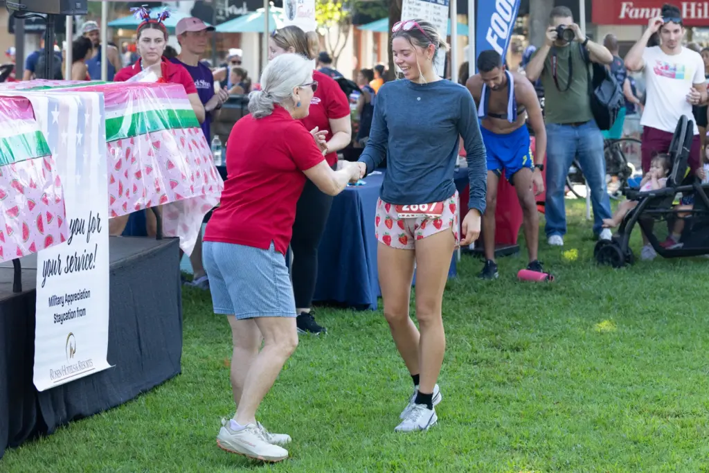 First place female runner Avery Latto, right, shakes hands with...