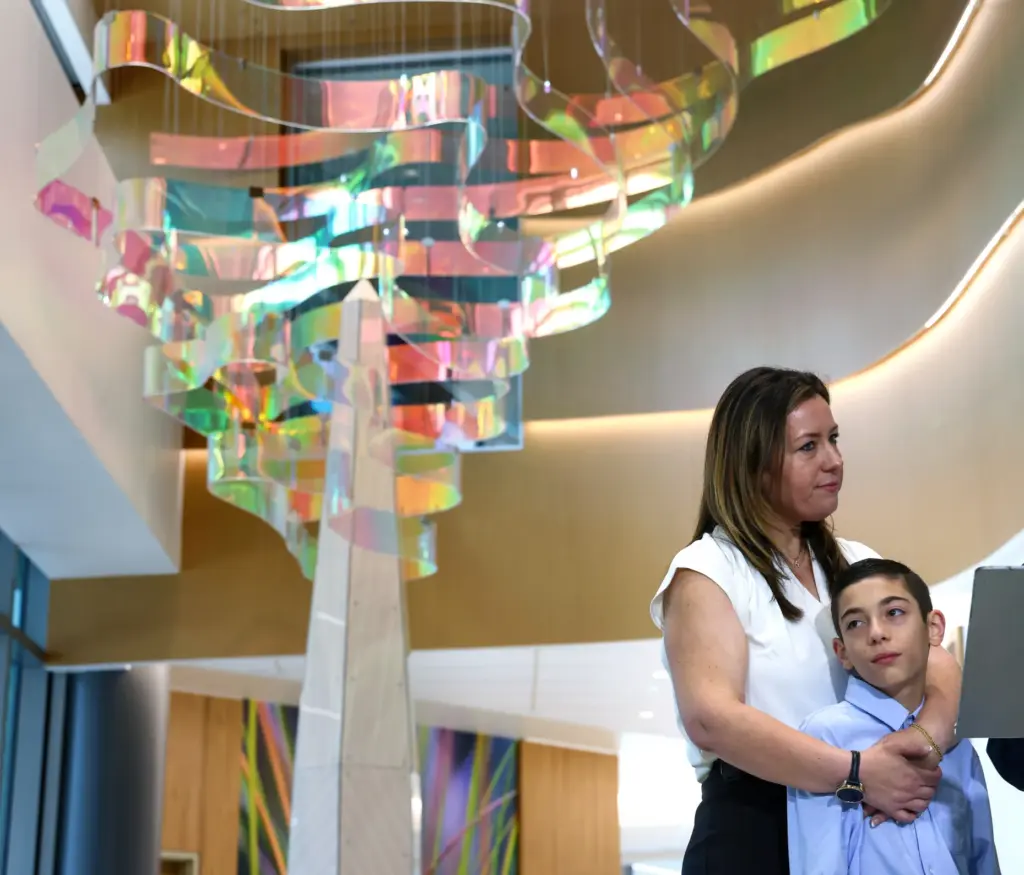 12-year-old Myles Murillo gets a hug from mom Katie as...