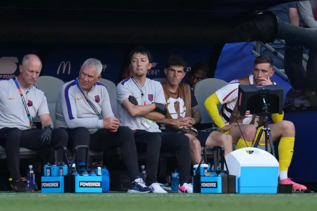 Christian Pulisic watches from the bench in the U.S.' game against Belgium.