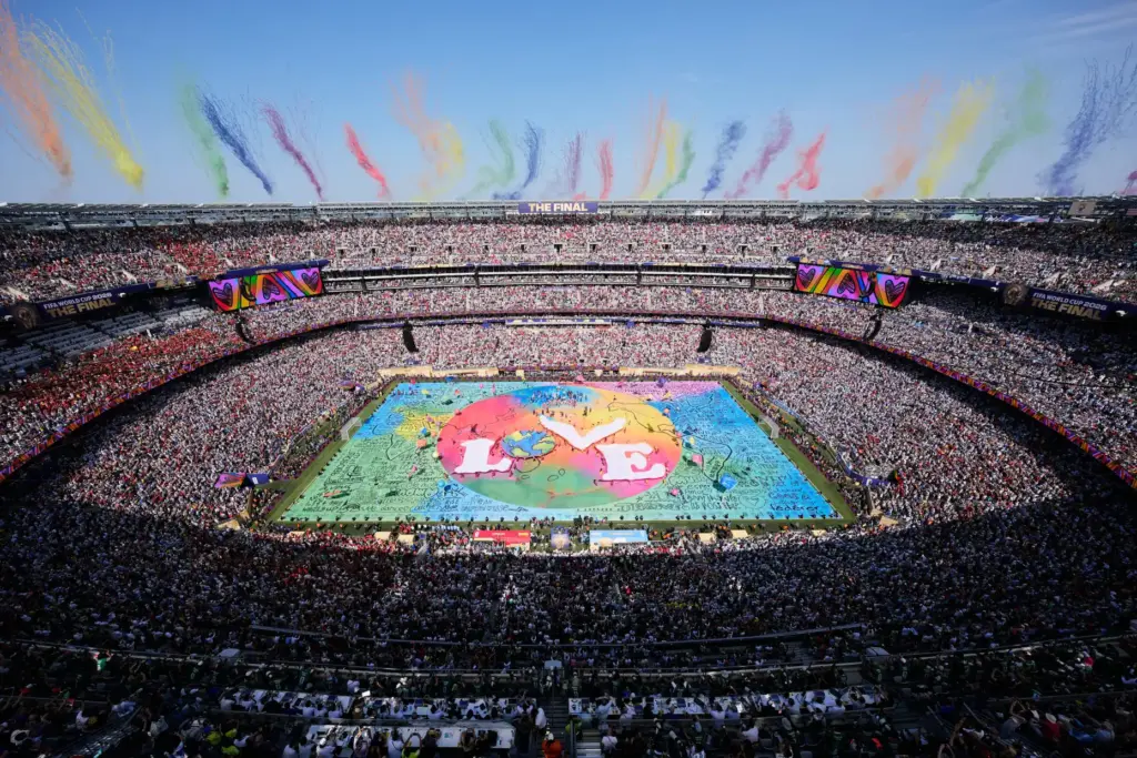 Dancers perform as colorful smoke rises above the stadium during...