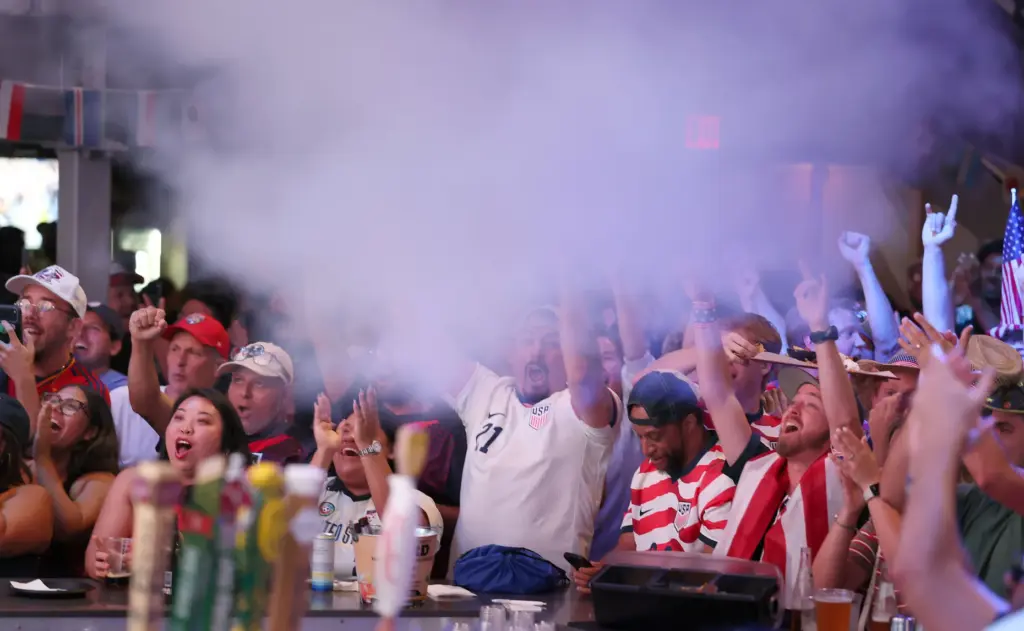 USA soccer fans cheer after a USA goal during a...