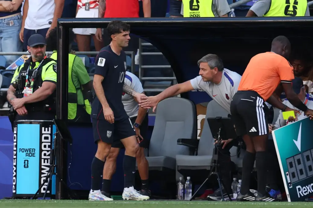 Christian Pulisic is greeted by a team member as he is being substituted.