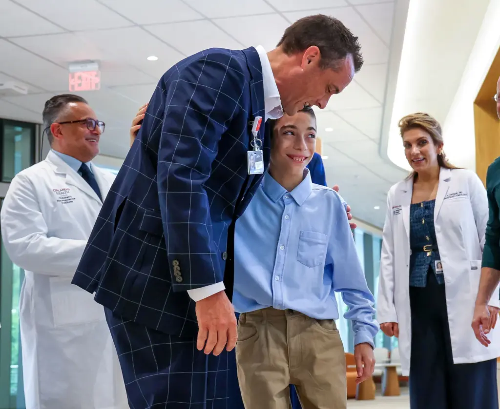 Orlando Health senior vice president Justin Williams congratulates 12-year-old Myles...
